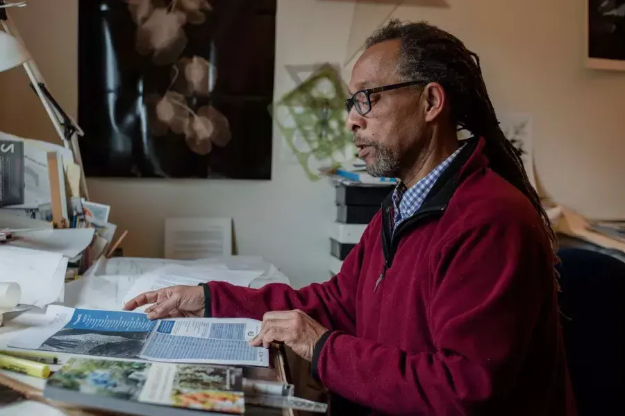 罗恩·莫尔特里·桑德斯 sitting at his desk reading